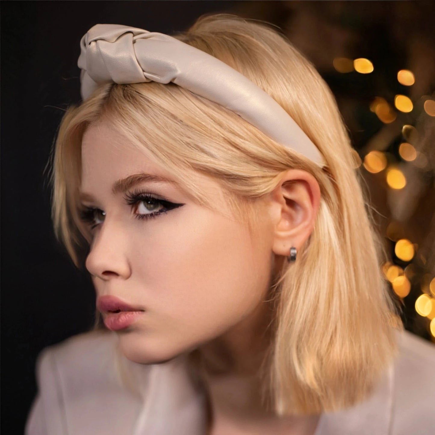 Blond haired model from side is wearing white headband by Malkiele