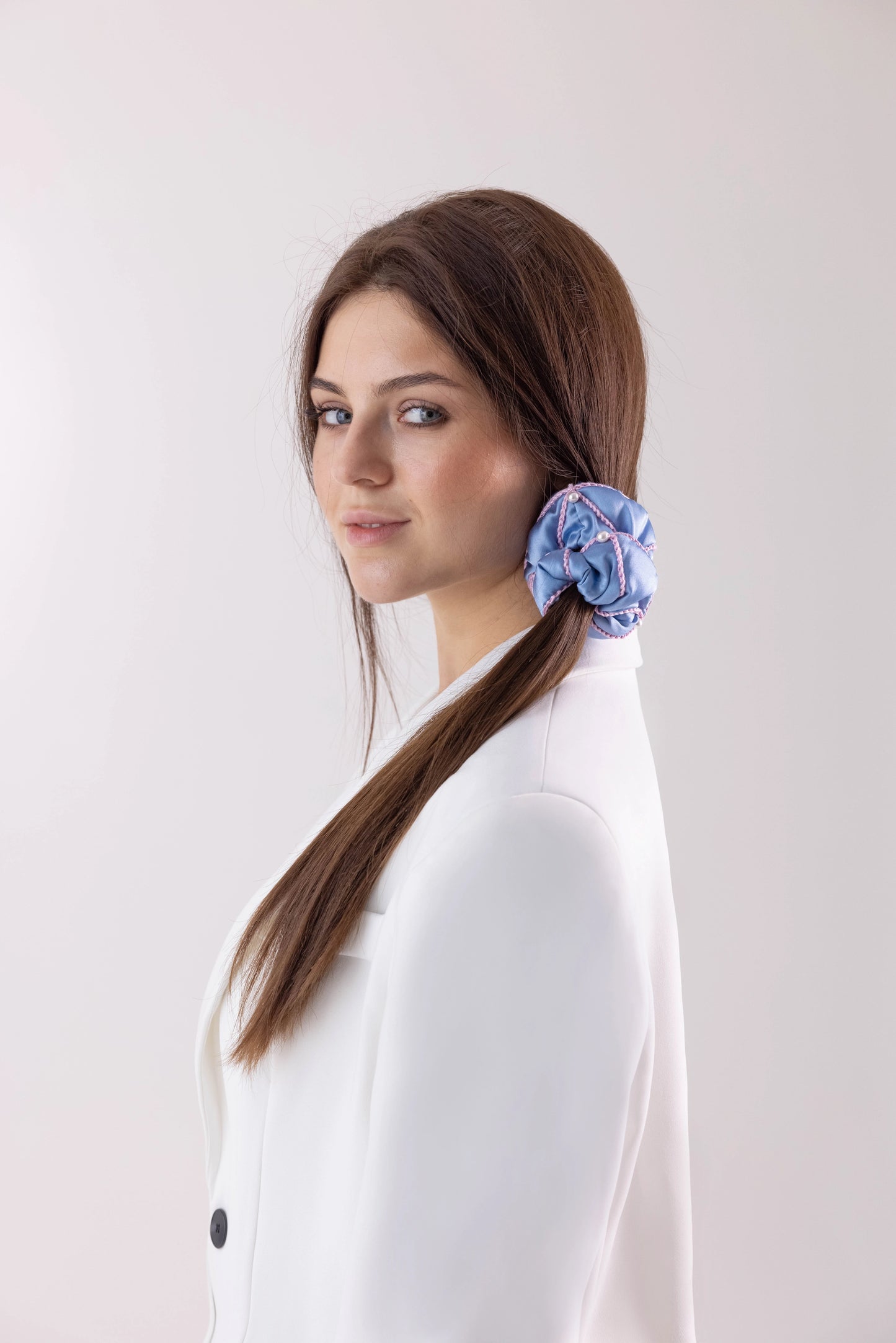 Dark hair girl with stylish ponytail is wearing light blue silk scrunchie embellished with pearls from Swarovski® by Malkiele sustainable designer for gentle hair care