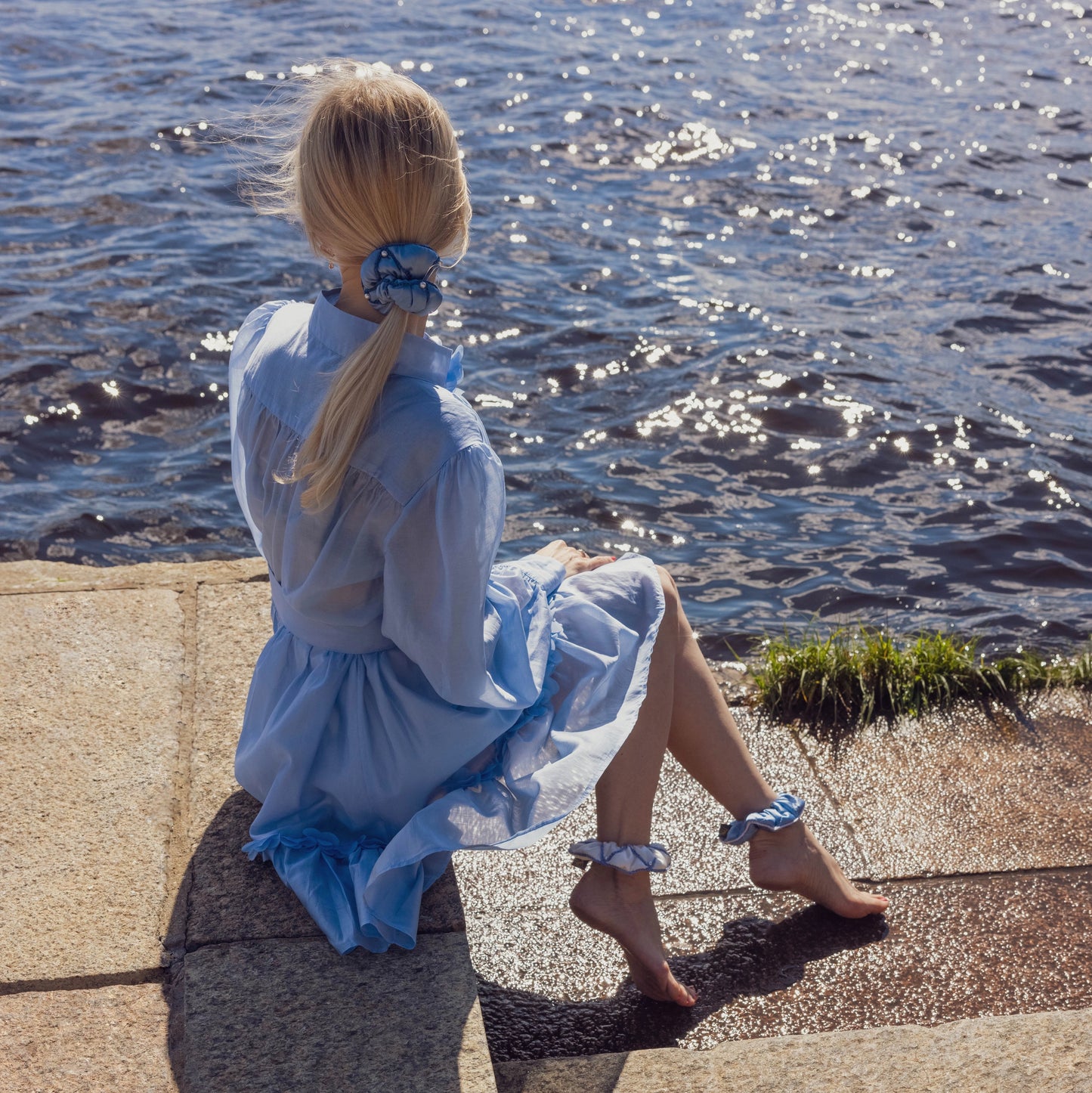 Sophisticated blonde-haired girl in light blue dress is wearing Malkiele designer Majestic 6 Pearls silk scrunchie, stylish ponytail.