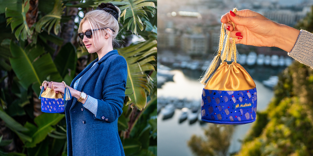 A blonde-haired girl is holding art suede blue bag with Swarovski crystals.