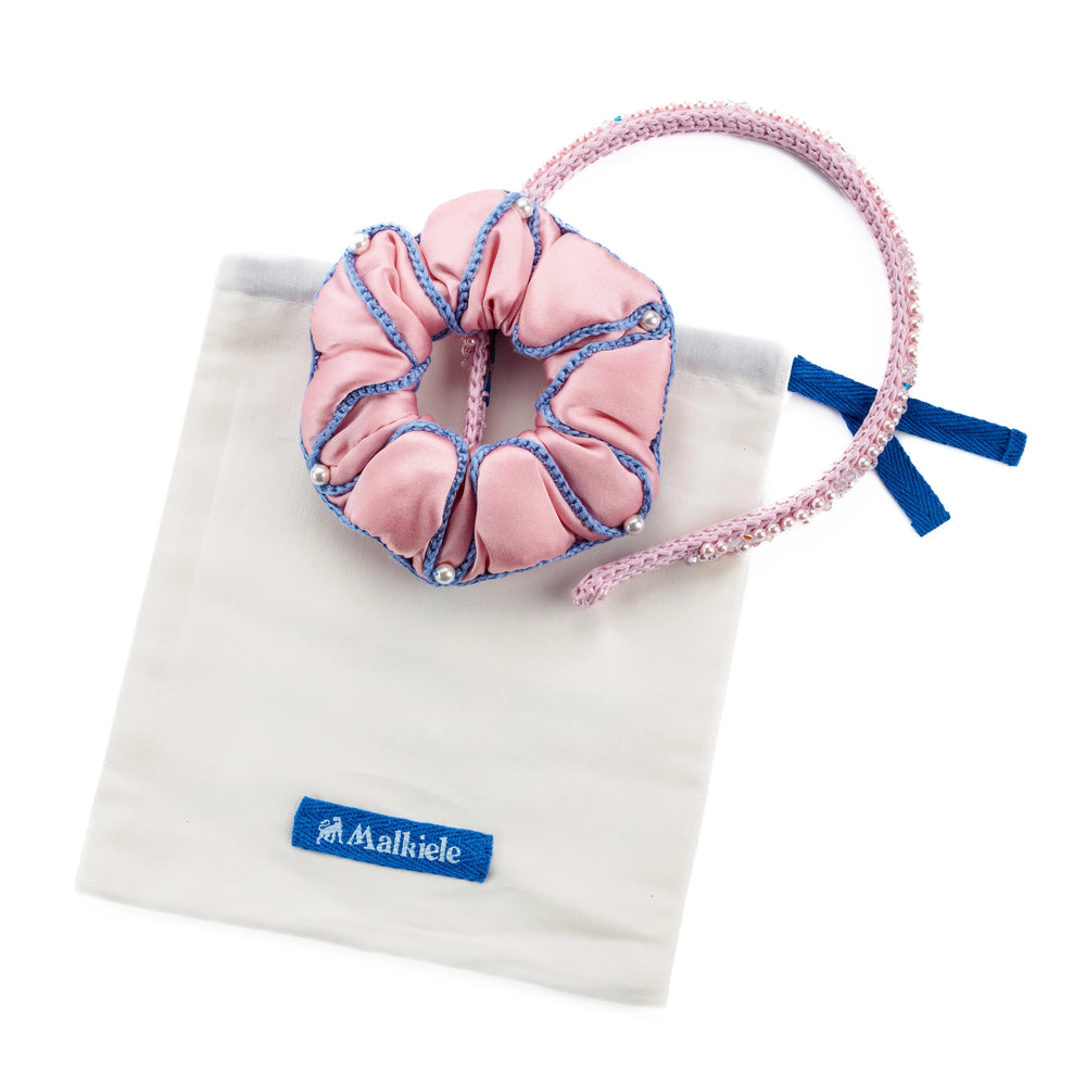 Malkiele designer premium white dust bag and pink scrunchie with headband are placed on it.