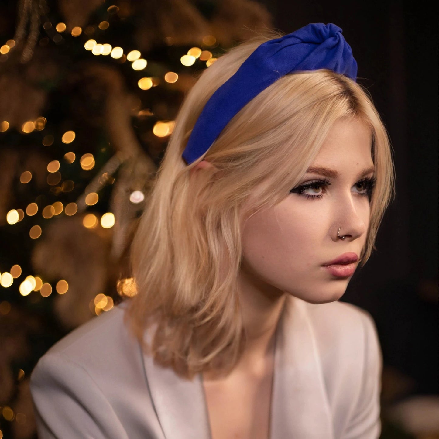 Blond-haired girl is wearing suede leather in blue from Malkiele, side view