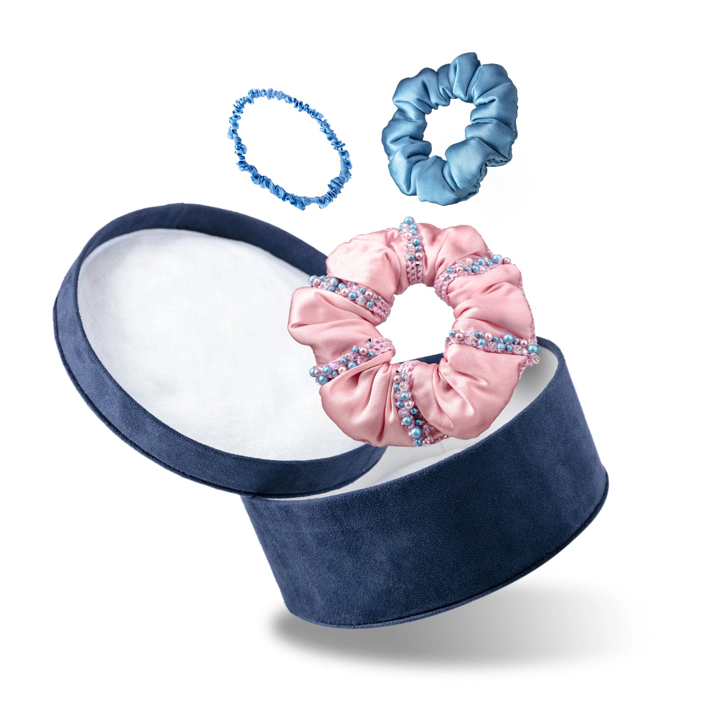 Malkiele designer, gift set consists of dark blue round velvet box with open cover, light blue silk hair tie, light blue silk scrunchie and pink silk scrunchie, embellished with crystals from Swarovski®, name Sumptuous.