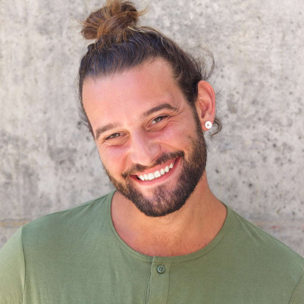 
                  
                    A smiling man with a bun wears Malkiele silk hair tie
                  
                