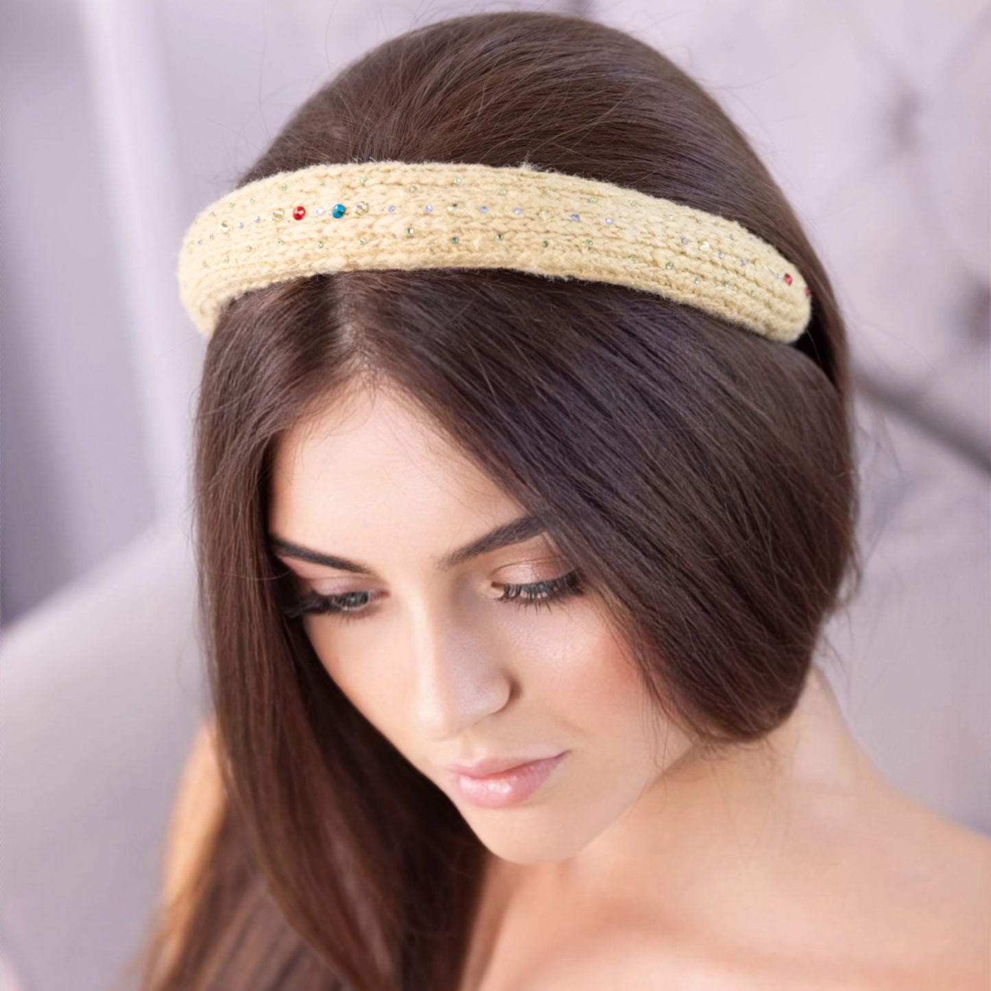 
                  
                    A dark-haired woman, is wearing Malkiele designer yellow silk knit headband, embellished with crystals from Swarovski, name Lofty.
                  
                