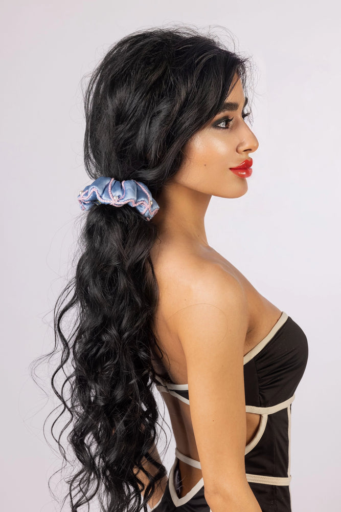 
                  
                    A black-haired woman, with stylish ponytail is wearing Malkiele designer light blue silk scrunchie, embellished with 6 white pearls from Swarovski and pink silk knit ribbon, name Majestic.
                  
                