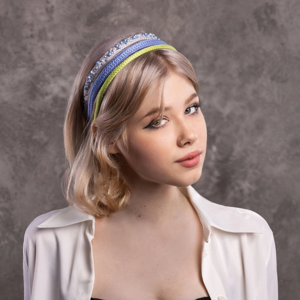 
                  
                    A blonde-haired girl is wearing Malkiele designer three silk knit headbands, grey is embellished with pearls from Swarovski®, light blue and light green silk headbands.
                  
                