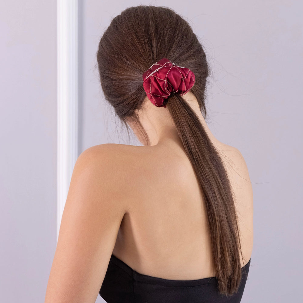 
                  
                    A dark-haired woman, view from the back, with stylish ponytail is wearing Malkiele designer burgundy silk scrunchie, embellished beige silk knit ribbon, name Morning Passion.
                  
                