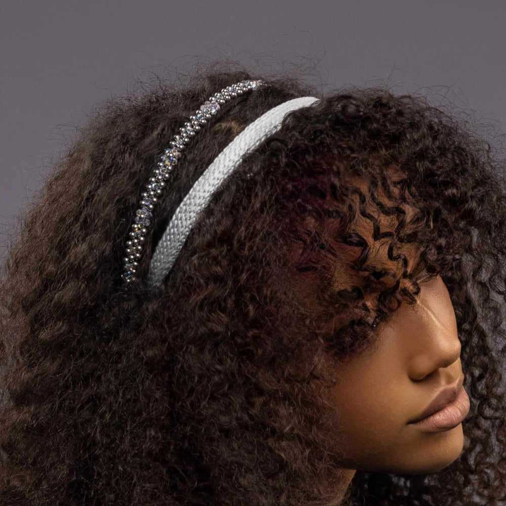 
                  
                    A dark-haired girl is wearing Malkiele designer grey silk knit headbands, one is embellished with light blue pearls from Swarovski, details, name Perfect.
                  
                