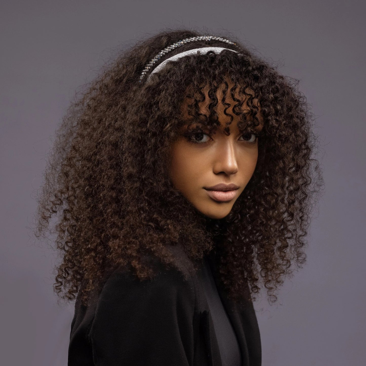 
                  
                    A dark-haired girl, front view, is wearing Malkiele designer grey silk knit headbands, one is embellished with light blue pearls from Swarovski, name Perfect.
                  
                