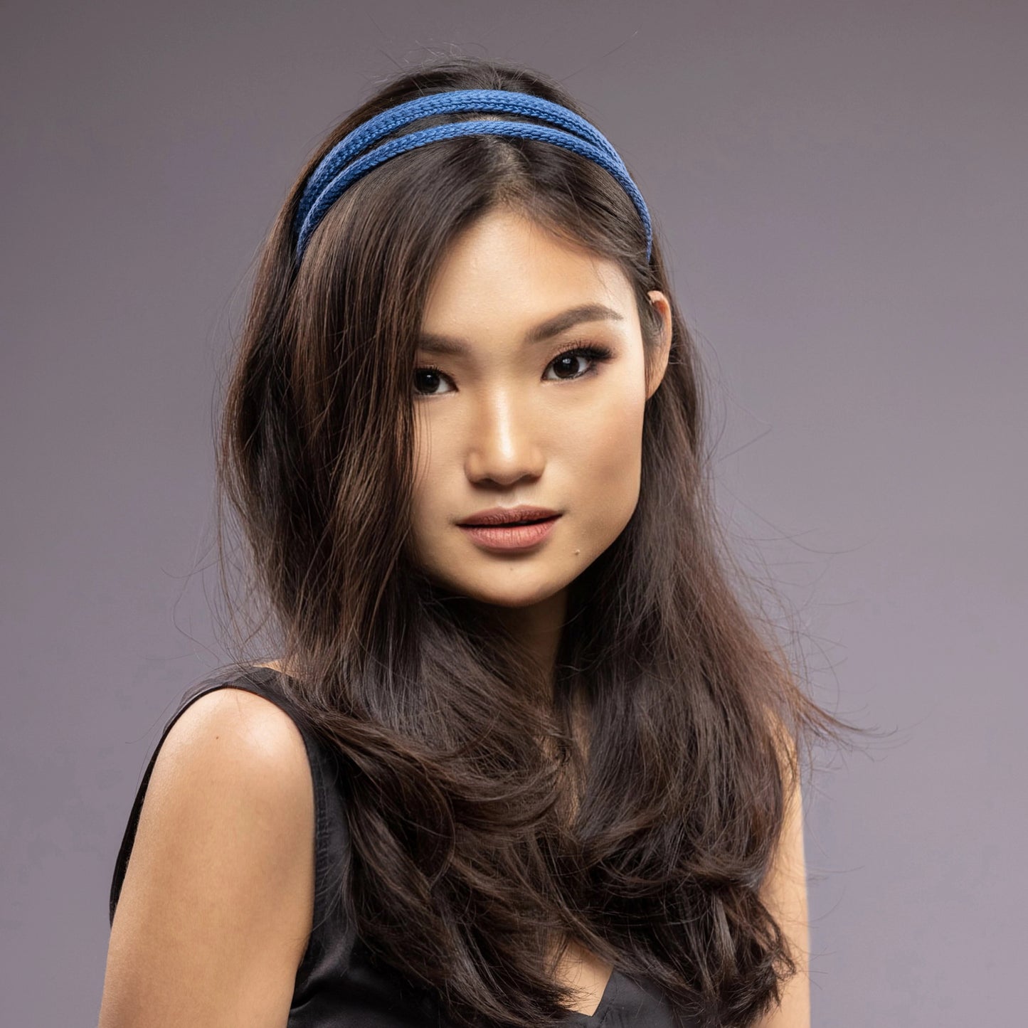 
                  
                    A dark-haired asian woman is wearing Malkiele silk knit headbands in blue, name Perfect
                  
                