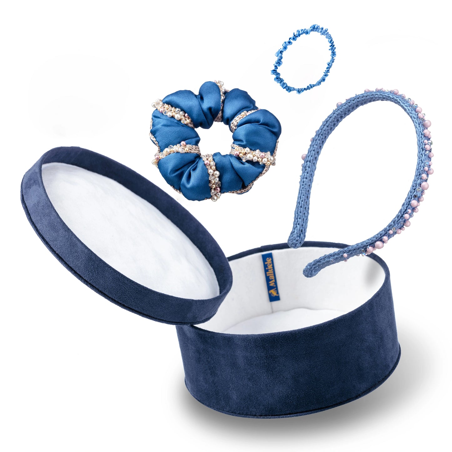 Malkiele designer, gift set consists of dark blue round velvet box with open cover, light blue silk hair tie, blue silk scrunchie and light blue silk knit headband, embellished with crystals from Swarovski®, name Precious.