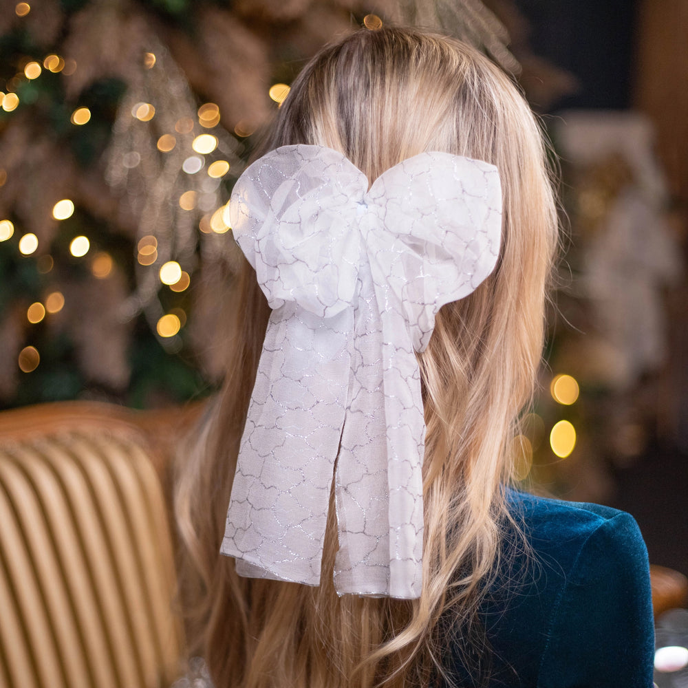 A blonde-haired woman is wearing Malkiele Art Chiffon bow in white, name Romantic