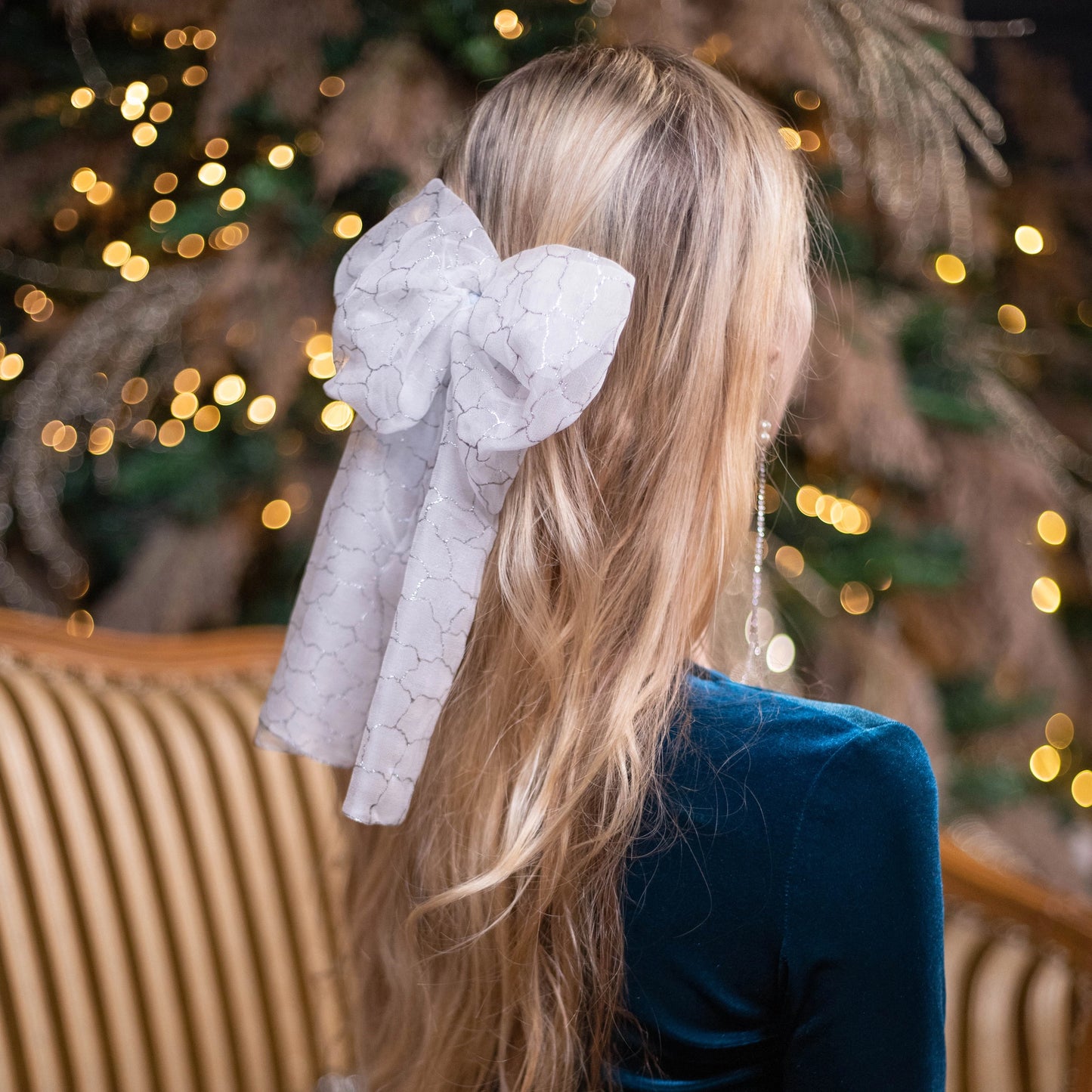 
                  
                    A blonde-haired woman is wearing Malkiele Art Chiffon bow in white, name Romantic
                  
                