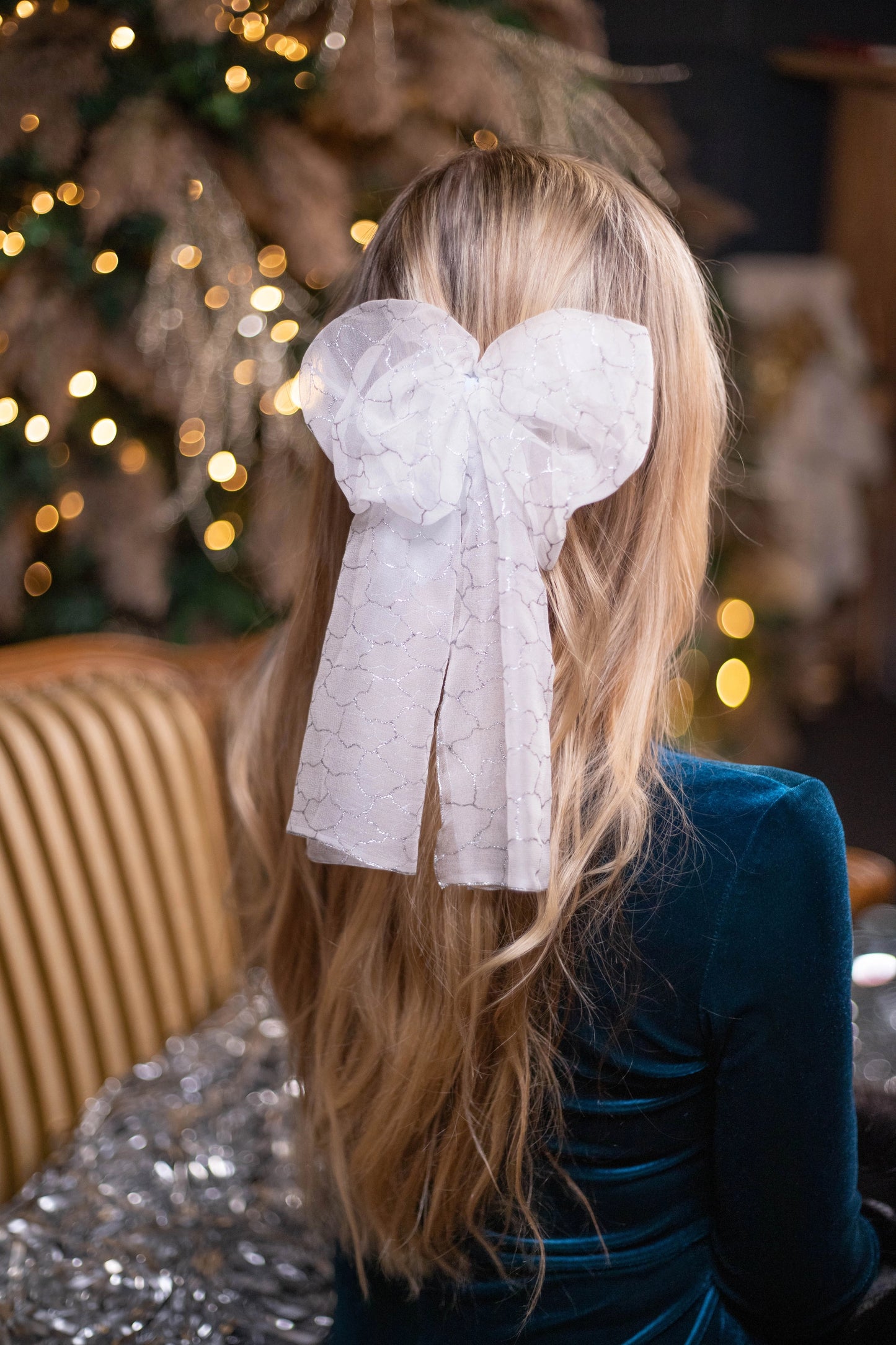 
                  
                    A blonde-haired woman is wearing Malkiele Art Chiffon bow in white, name Romantic
                  
                