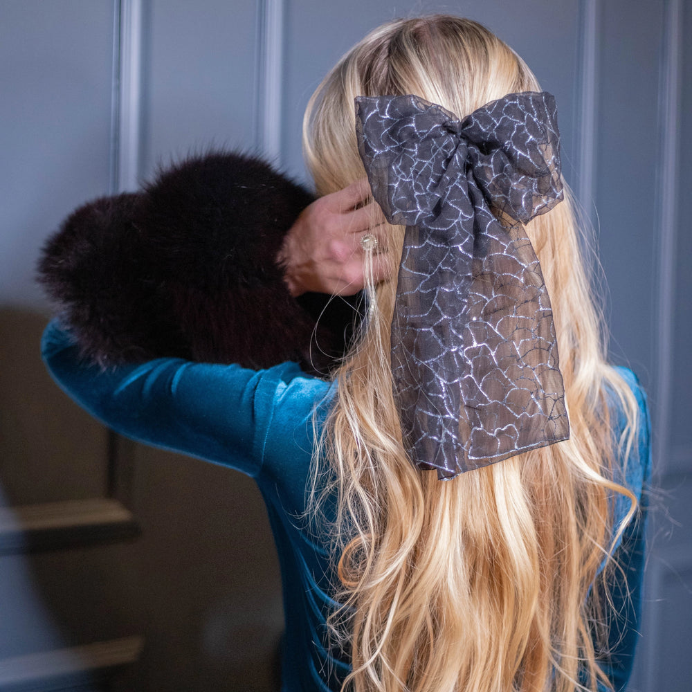 A blonde-haired girl is wearing Malkiele Art Chiffon bow in black, name Romantic