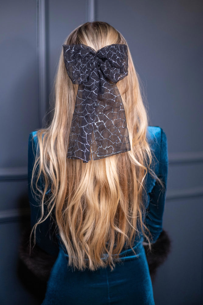 
                  
                    A blonde-haired girl is wearing Malkiele Art Chiffon bow in black, name Romantic, back view
                  
                