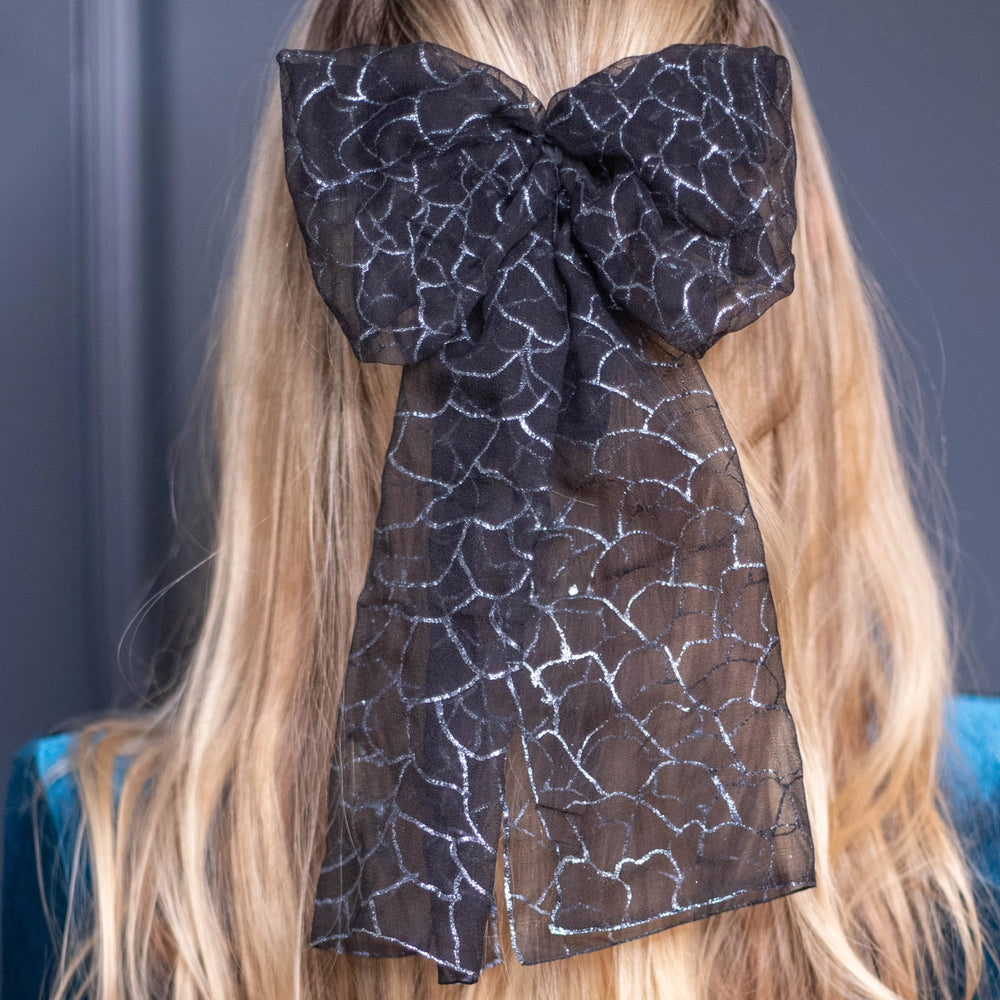 
                  
                    A blonde-haired girl is wearing Malkiele Art Chiffon bow in black, name Romantic, details
                  
                