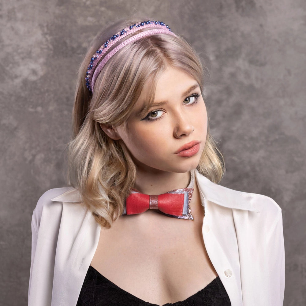 
                  
                    A blonde-haired girl is wearing Malkiele designer, pink three silk knit headbands, one is embellished with blue pearls from Swarovski®, the other one is embellished with coral leather bow on her neck.
                  
                