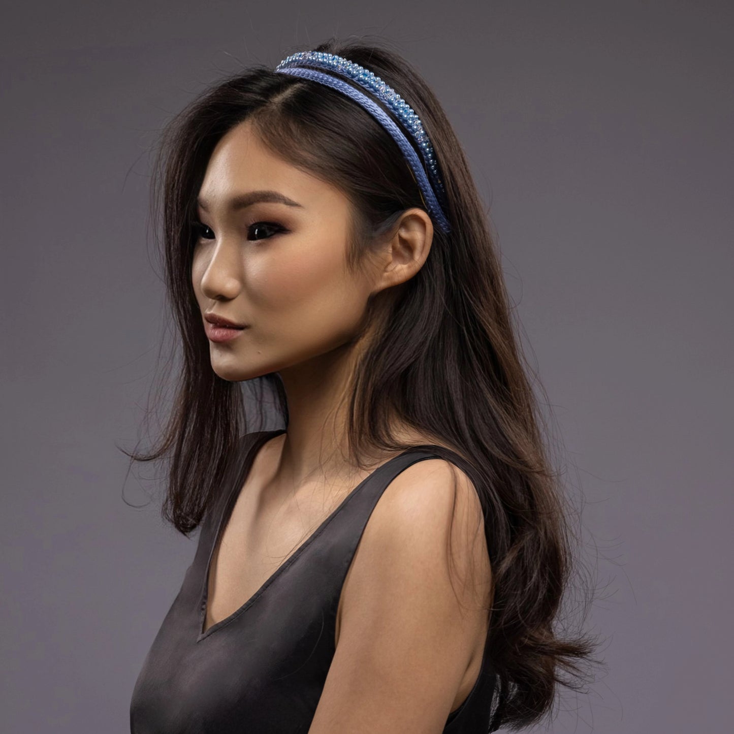 
                  
                    A dark-haired asian woman is wearing Malkiele designer silk headbands in light blue, name Victorious
                  
                