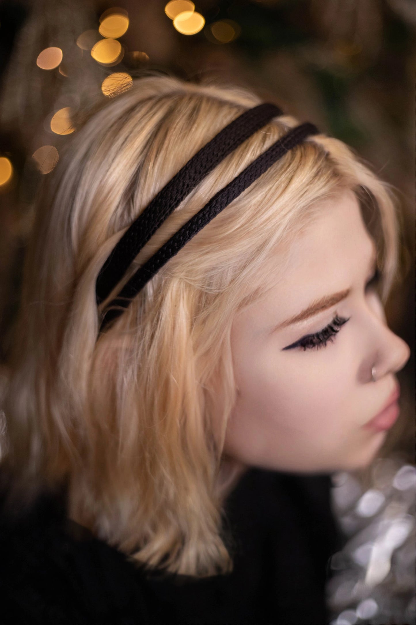 
                  
                    A blonde-haired girl is wearing Malkiele silk knit headband in black, name Virgin, details
                  
                