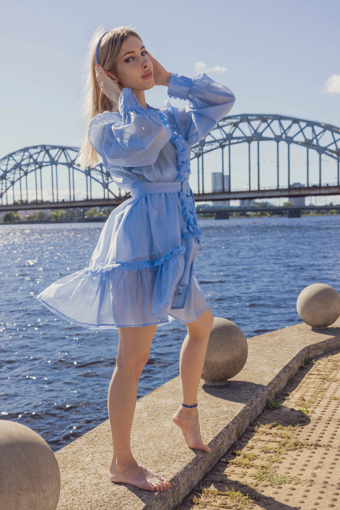 
                  
                    A blonde-haired girl in light blue dress, front view, is wearing Malkiele designer light blue silk knit headband, name Virgin.
                  
                