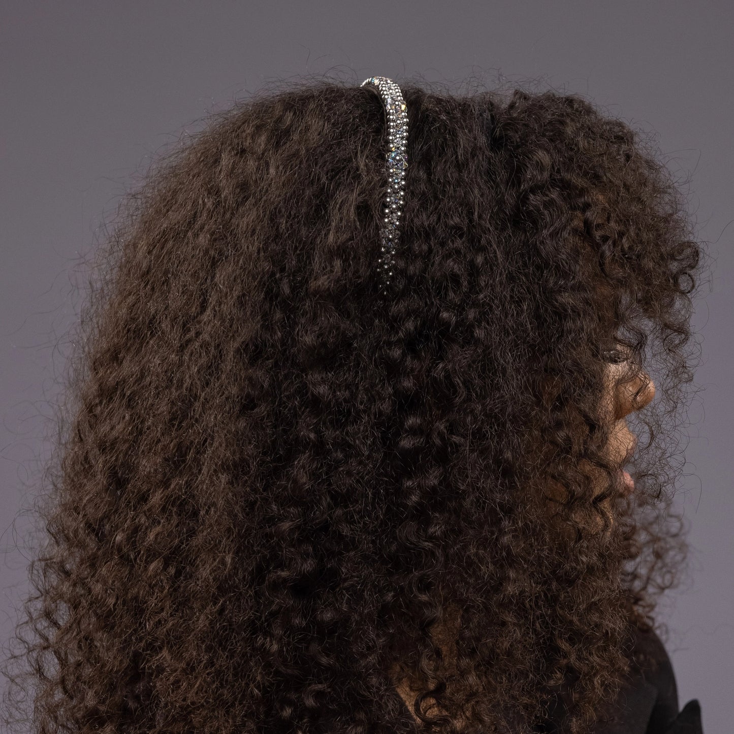 
                  
                    A dark-haired African woman is wearing Malkiele designer black silk knit headbands, embellished with pearls from Swarovski, name Victorious.
                  
                