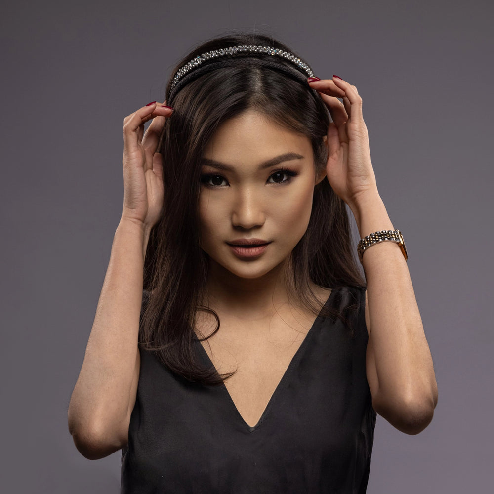 
                  
                    A dark-haired Asian girl is wearing Malkiele designer black silk knit headbands, embellished with pearls from Swarovski, name Victorious.
                  
                