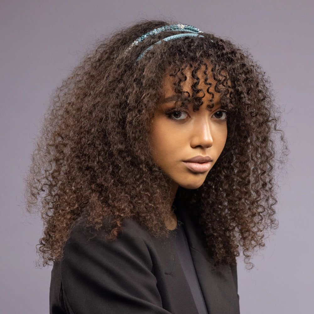 
                  
                    A dark-haired African woman is wearing Malkiele designer green silk knit headbands, embellished with pearls from Swarovski, name Victorious.
                  
                