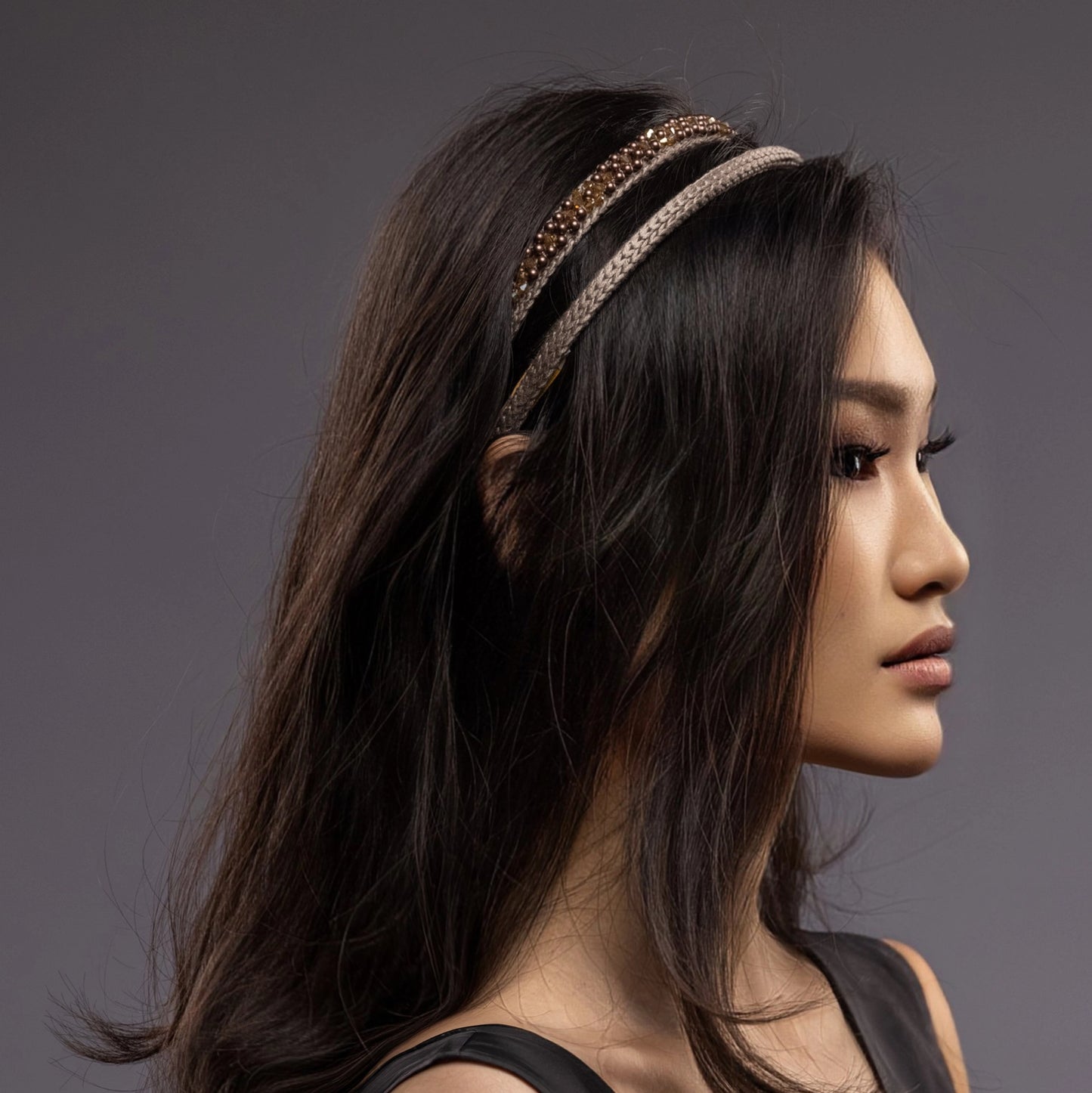 
                  
                    A dark-haired Asian girl is wearing Malkiele designer beige silk knit headbands, embellished with pearls from Swarovski, details, name Victorious.
                  
                