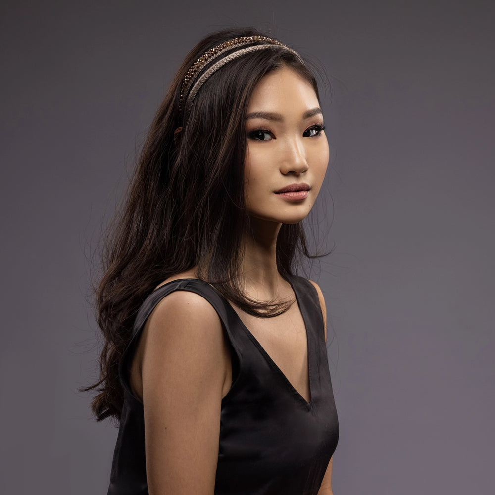 
                  
                    A dark-haired Asian girl is wearing Malkiele designer beige silk knit headbands, embellished with pearls from Swarovski, name Victorious.
                  
                