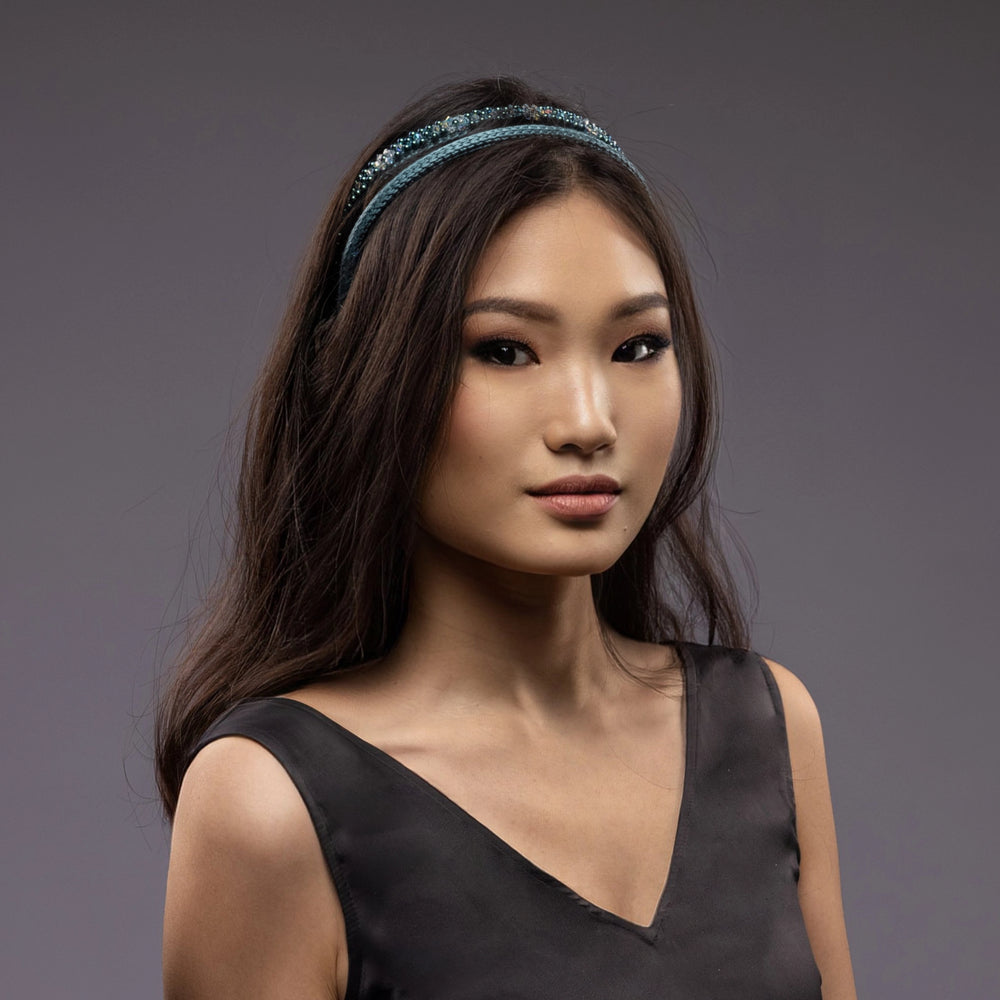 
                  
                    A dark-haired Asian girl is wearing Malkiele designer green silk knit headbands, embellished with pearls from Swarovski, name Victorious.
                  
                