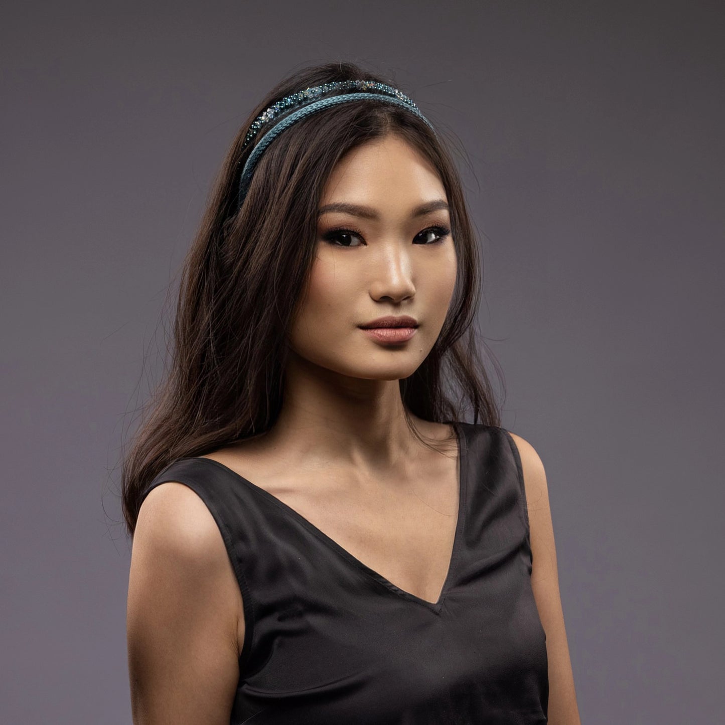 
                  
                    A dark-haired Asian woman is wearing Malkiele silk knit headbands in green, name Virgin
                  
                